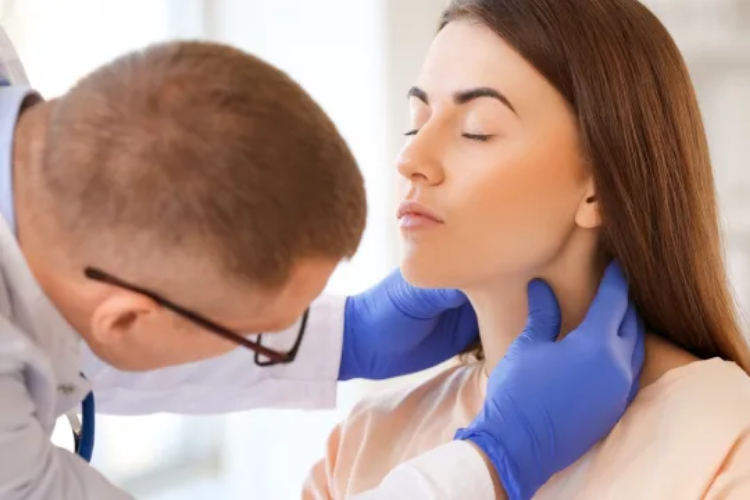 Doctor examining woman's neck. Click to register.