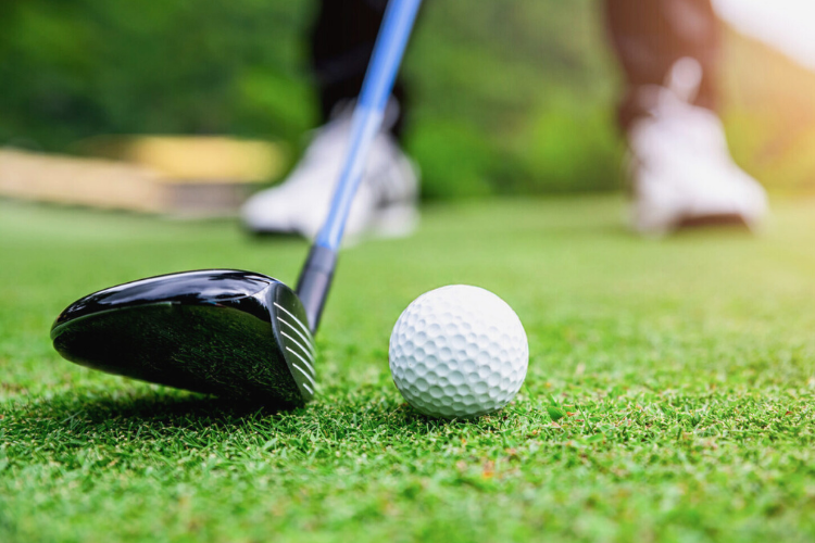Close up of golf club and golf ball on grass. Click to register.