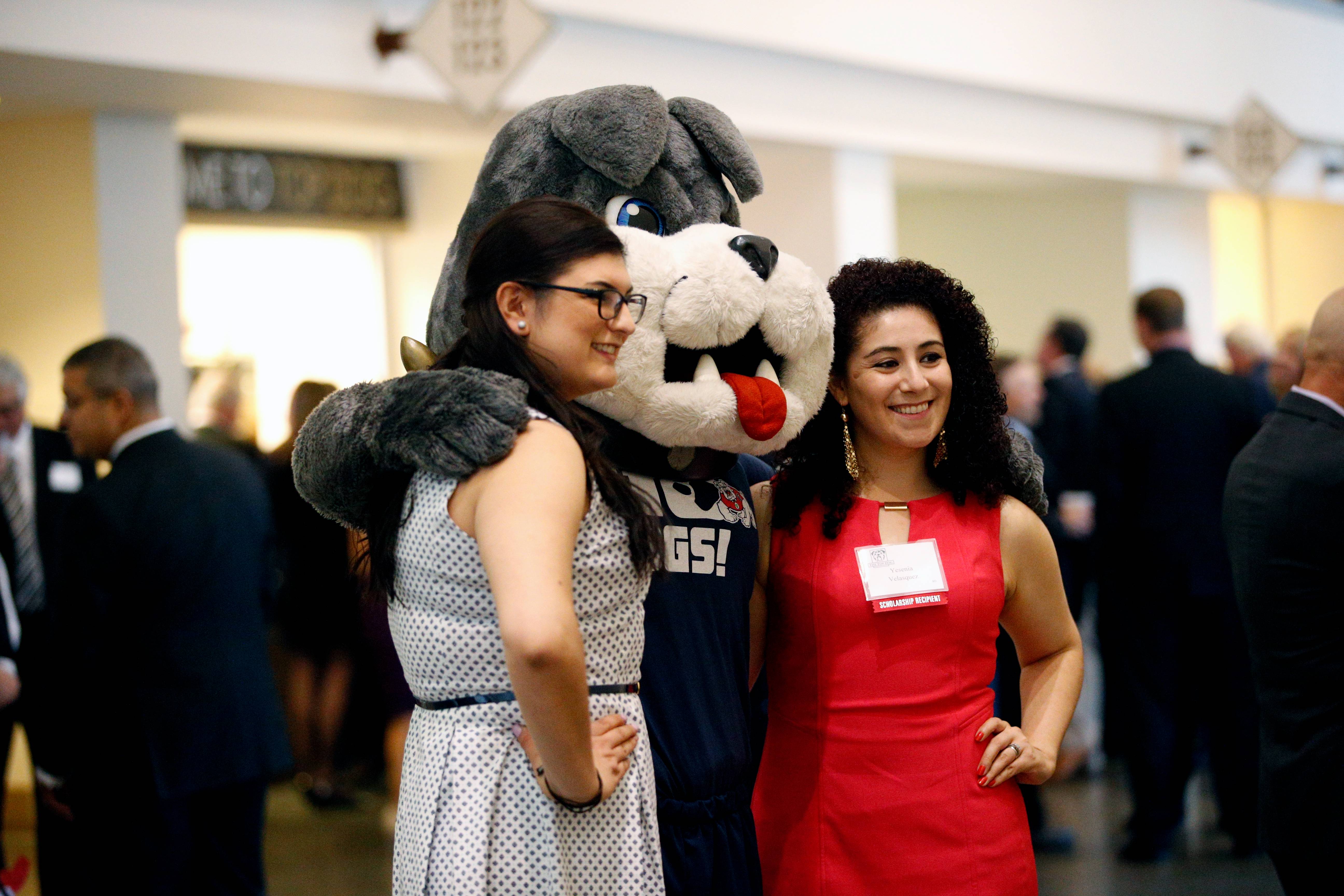 TimeOut mascot poses with two alumna.