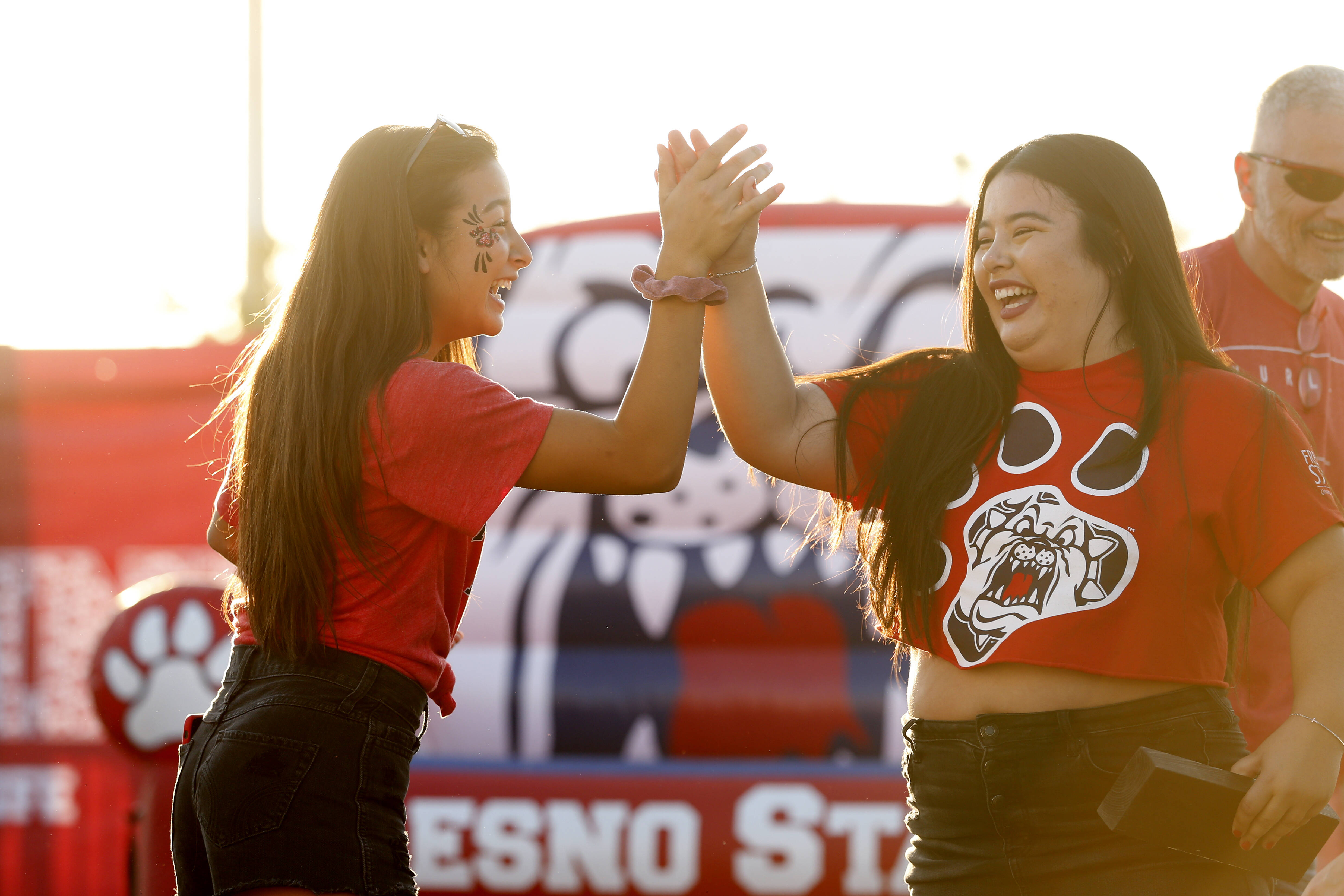 Two students giving high five to each other