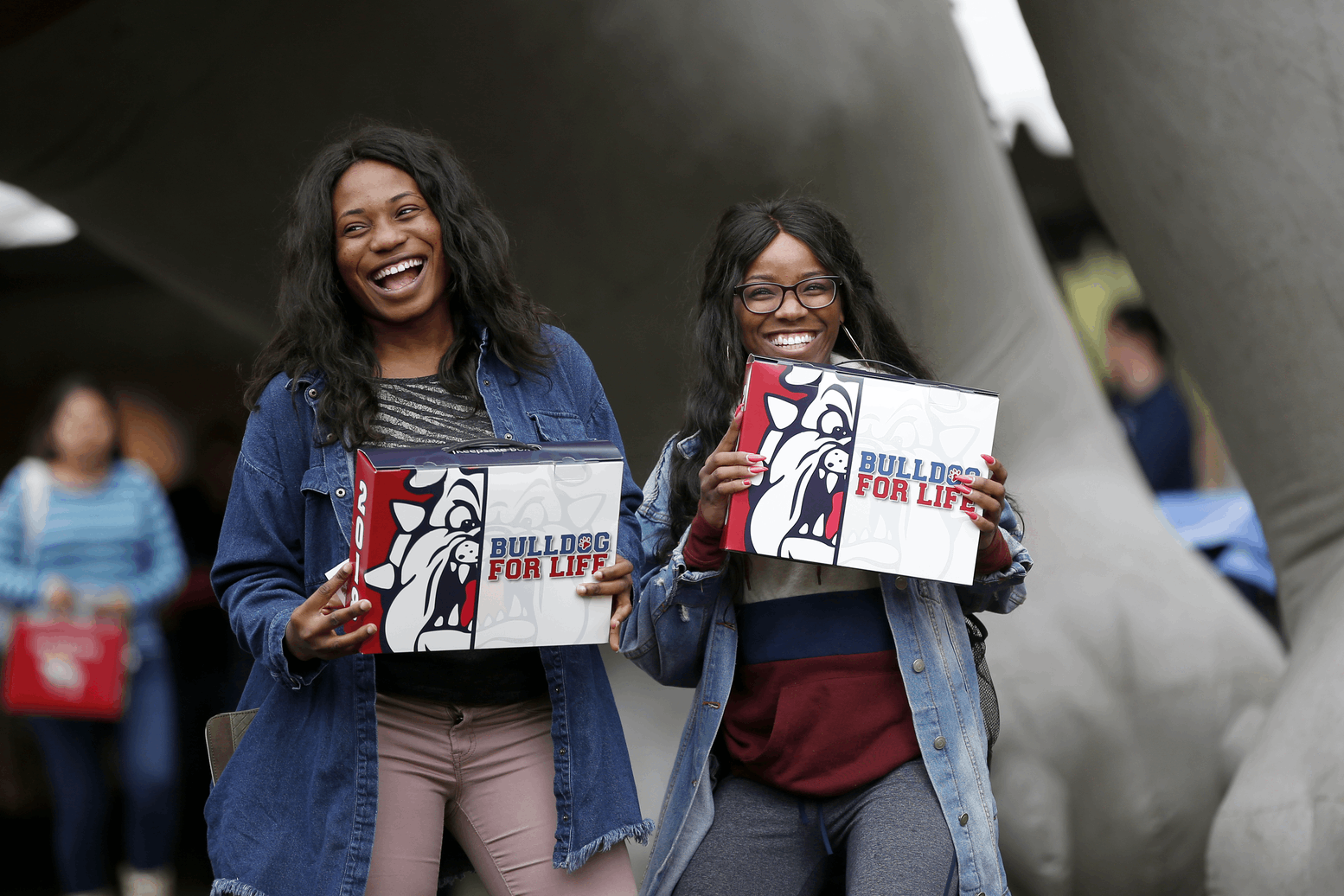 Two students holding Grad Boxes