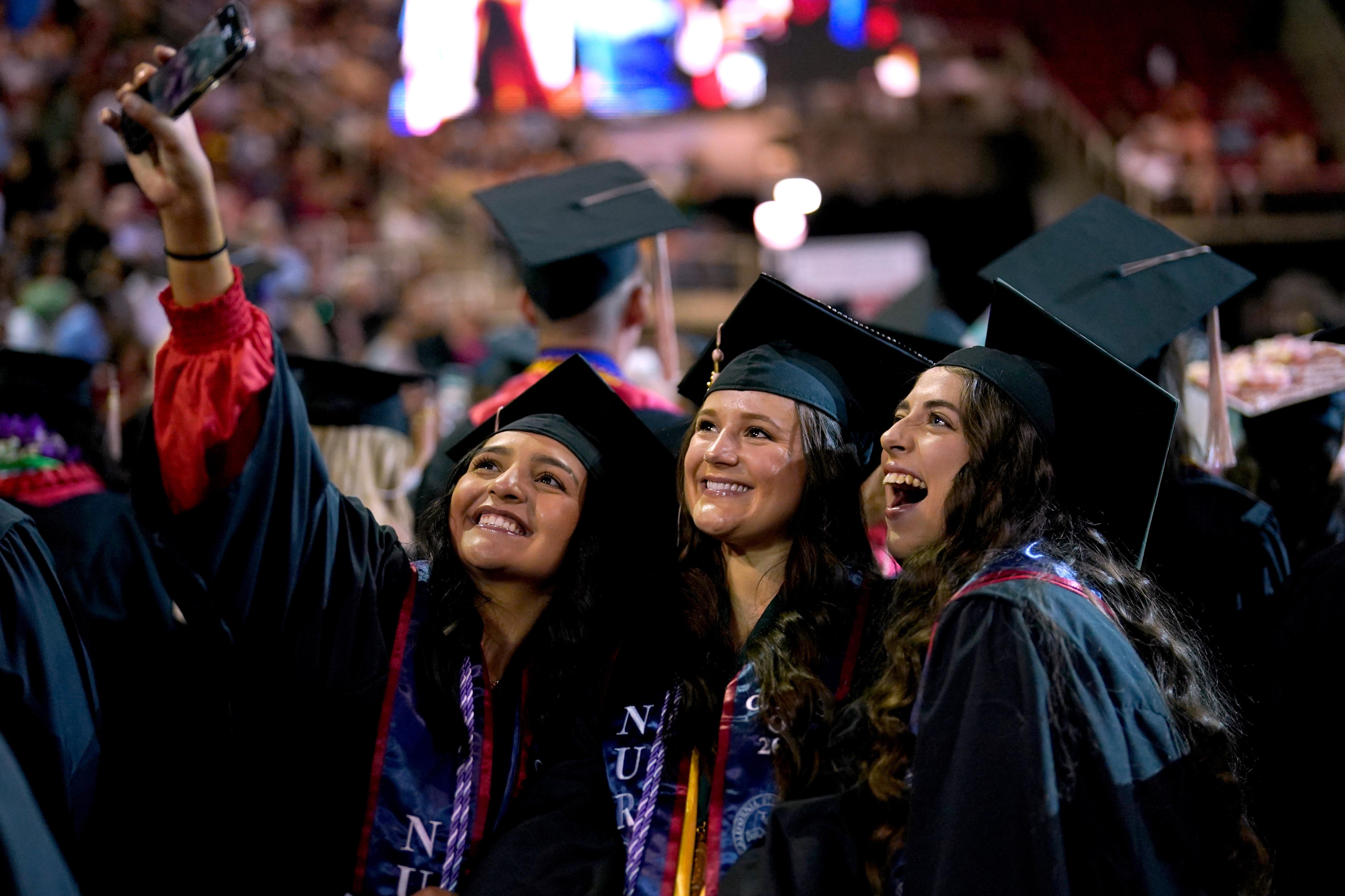 three graduates taking a selfie